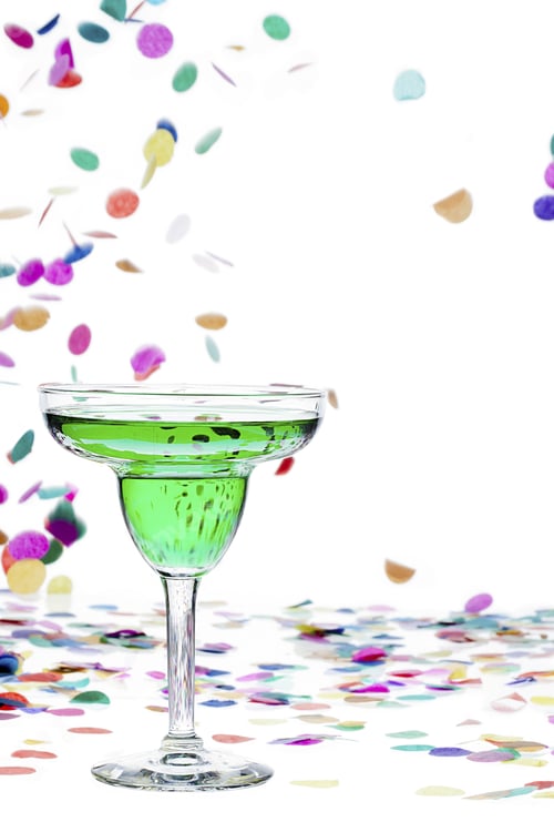 Preview: Close-Up Image Of A Green Drink In Martini Glass While Confetti Falling In Background.