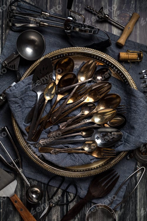Preview: Top Down View Of An Abstract Arrangement Of Antique Utensils Against A Dark Background.