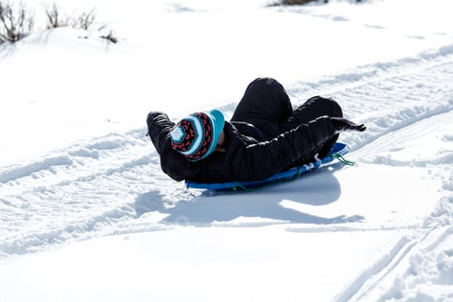 Preview: Child Riding A Sled Bundled In Warm Winter Clothing
