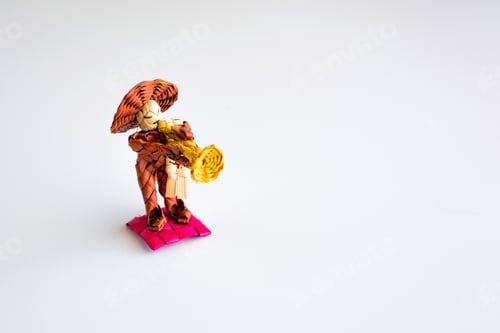 Preview: Woven Figure Plays Yellow Trumpet on Pink Pillow