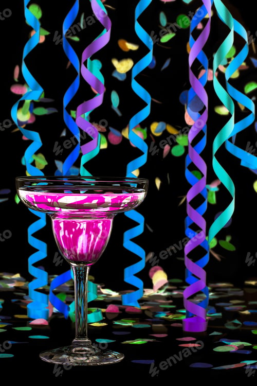 Preview: Close-Up Shot Of Martini With Pink Drink And Colorful Streamers And Confetti Over Dark Background.