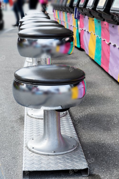 Preview: Vertical View Of A Row Of Round Stools At An Arcade Game At A Fair Ground Midway