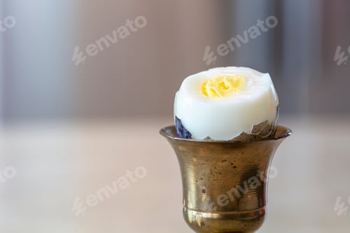 Preview: Hard Boiled Quail Egg In Brass Egg Holder With Shell Cracked Open Ready To Be Eaten