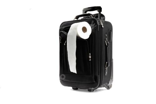 Preview: A Roll Of Toilet Paper In The Cover Of A Black Carry On Suitcase Isolated On White