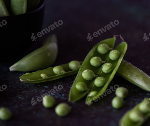 Preview: Close Up View Of Snap Pea Pods Against A Dark Background.