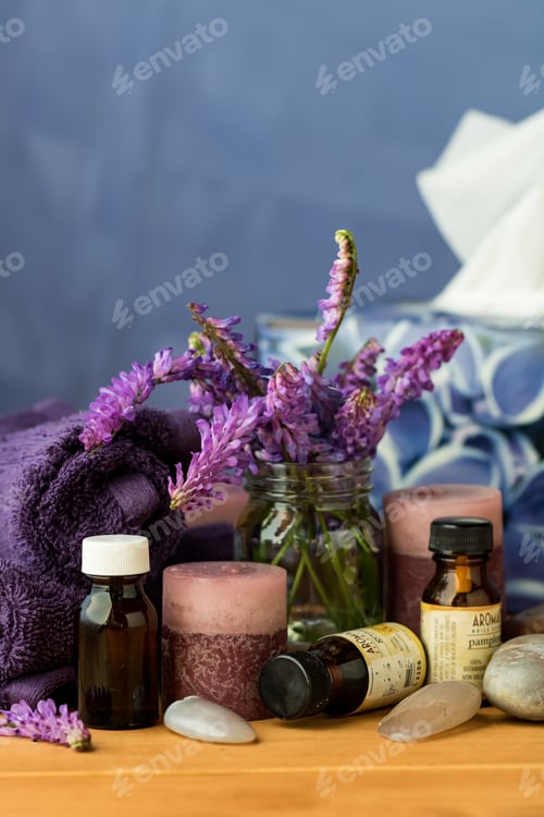 Visualização: Vista de perto de um arranjo de itens de aromaterapia, como óleos essenciais, velas de lavanda e