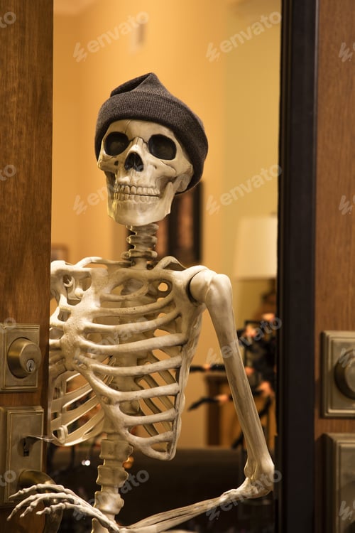 Preview: Halloween Skeleton Greeting At The Door Wearing A Knitted Hat