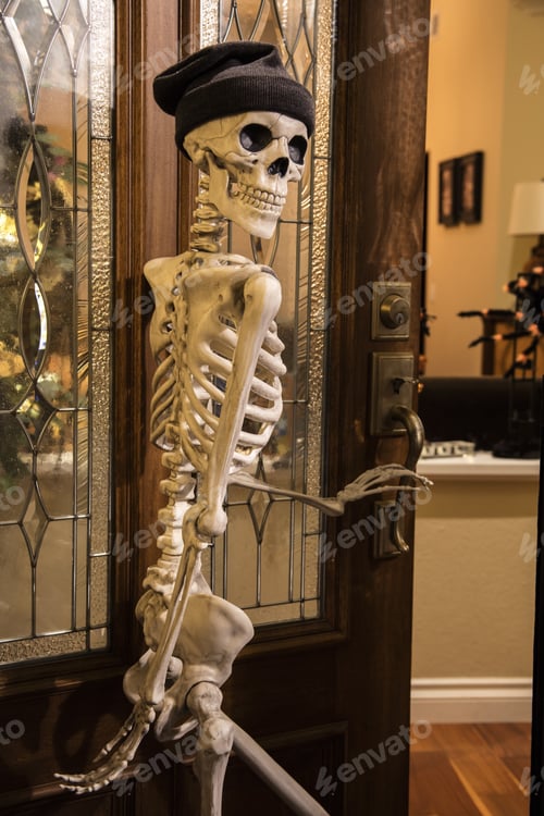 Preview: Halloween Skeleton Greeting At The Door Wearing A Knitted Hat