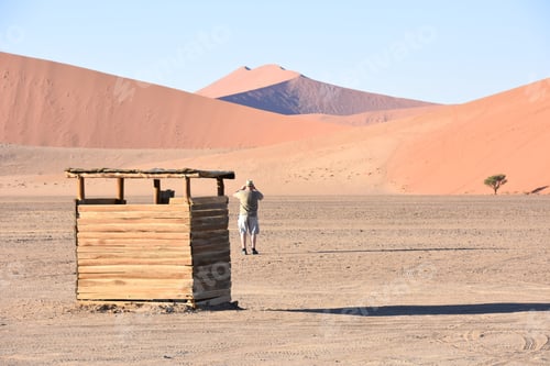 Vista previa: A Tourist Standing Near The Famous Sand Dunes In The Namib-Naukluft Park Area In Namibia Southern