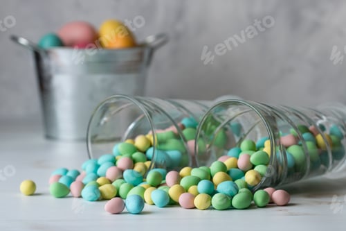 Preview: Close Up View Of Two Glasses Tipped Over With Chocolate Mini Easter Eggs Spilling Out.