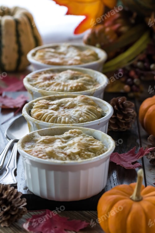 Preview: A Front View Of Some Turkey Pot Pies Backlit Against A Sunny Window And Surrounded By Fall