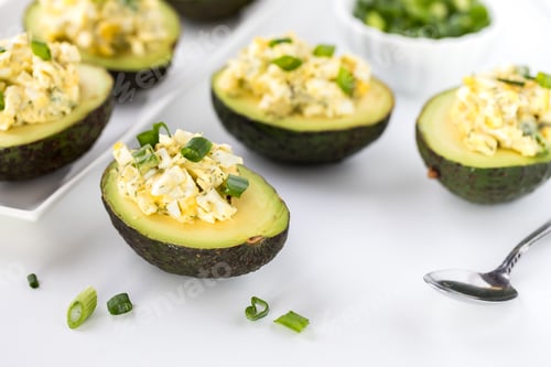 Preview: Close Up View Of Avocado Halves Filled With Egg Salad And Topped With Green Onion Ready For Eating.