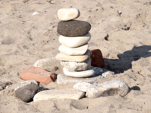 Preview: A Pile Of Rocks Like A Cairn On A Sandy Beach