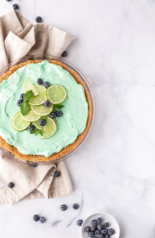 Preview: Top Down View Of A Key Lime Pie Beautifully Garnished With Lime Slices, Mint And Blueberries