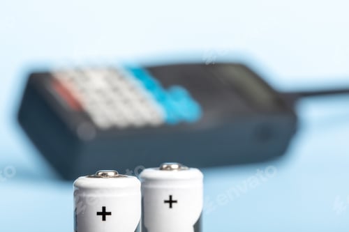 Preview: Two Double A Batteries With A Multi Band Police, Marine, Aviation Radio In The Background