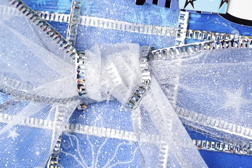 Preview: Close-Up Shot Of Knot Of Shiny Ribbon On Christmas Gift.