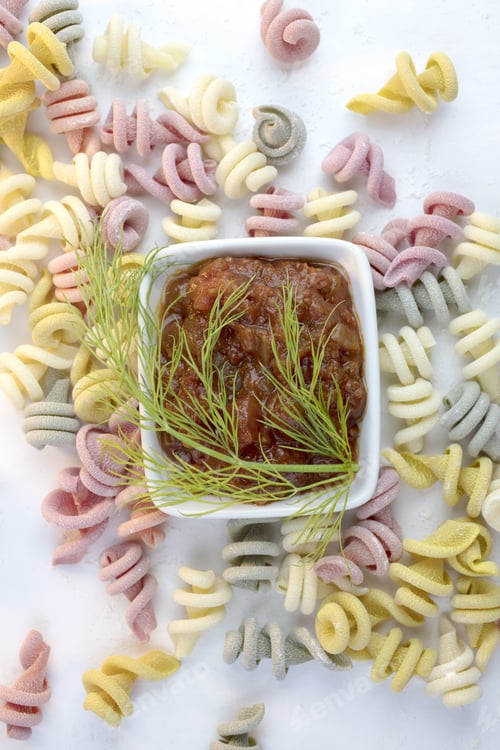 Preview: Curly And Twisted Pasta Shapes On A Cutting Board In Various Colors Of Pink, Yellow, Green And White