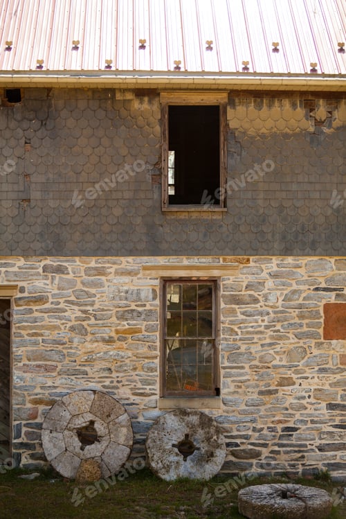 Preview: Old Mill Stones Leaning Against A Stone Wall Building In Lancaster County, Pa.