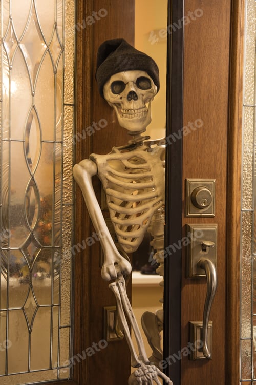 Preview: Halloween Skeleton Greeting At The Door Wearing A Knitted Hat