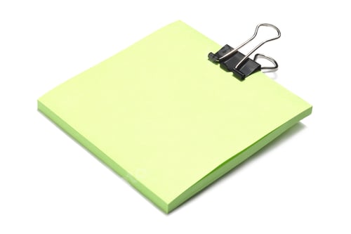 Preview: Close Up Image Of Green Adhesive Paper With Black Clip Against White Background