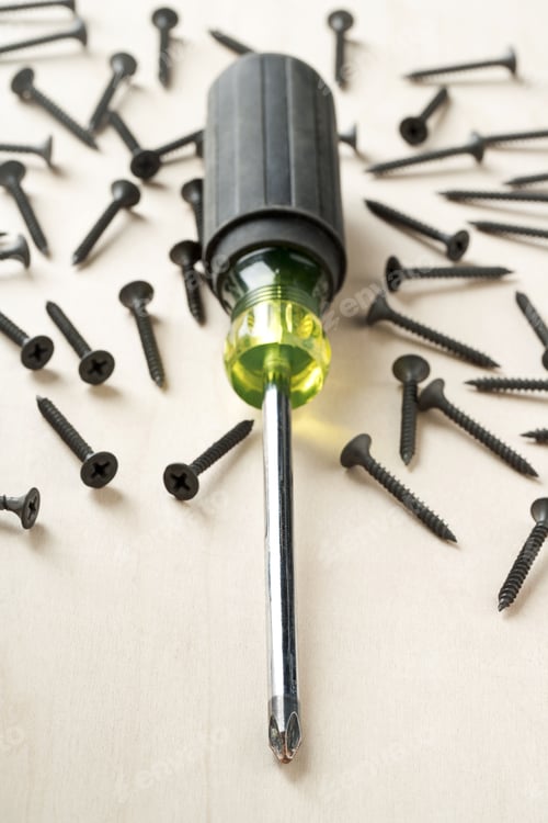Preview: Screwdriver With Screws On Wood Background