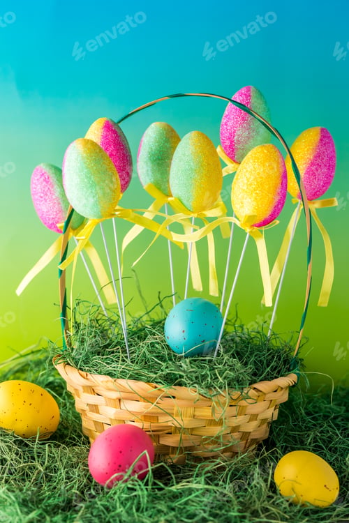Preview: A Close Up Of A Basket Of Colourful Easter Eggs Decorated With Sparkles Sitting On Grass.