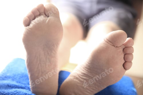 Preview: Closeup View Of Two Feet Of A Man With His Legs Propped Up
