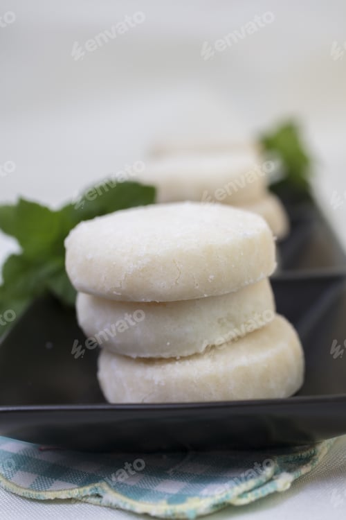 Preview: Lemon And Vanilla Shortbread Cookies Stacked On A Black Ceramic Dish On A Lace Doily And Garnished