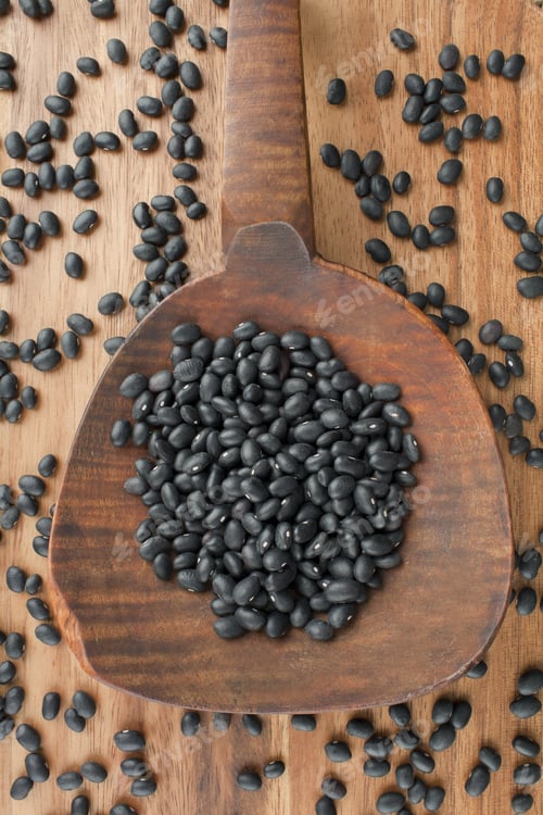 Preview: Vertical Image Of Spilled Black Beans On A Wooden Spoon On The Table