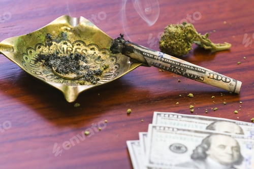Preview: Close Up Of A One Hundred Dollar Bill Joint With Smoke On One End In A Dark Room