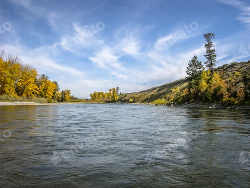 Preview: A View Of The Snake River In Wyoming Taken From A Boat With Wispy Clouds And Golden Trees In The