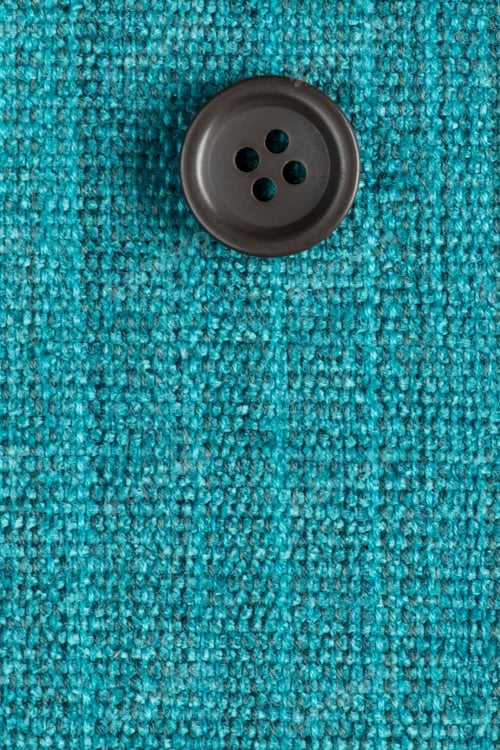 Preview: Clothes Sewing Button On A Turquoise Fabric Swatch Background