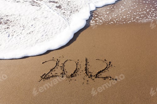 Visualização: 2012 Escrito na areia na praia com as ondas do mar começando a apagar a palavra