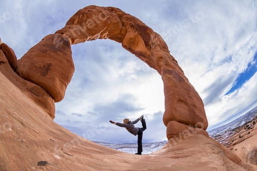Preview: Hiker Doing A Yoga Balancing Pose At The Base Of Delicate Arch