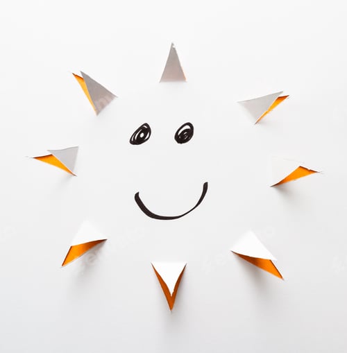 Preview: Abstract Paper Cut With Triangles Around A Main Circle To Form The Sun Shape On White And A Smile
