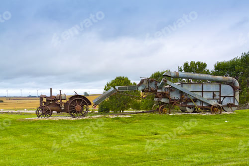 Preview: Old Rusty Tractor With Wind Turbines In The Background.