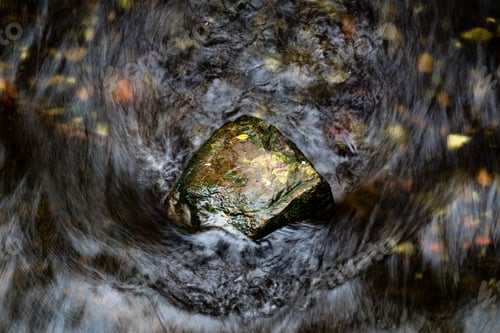 Preview: A Rock Situated In A Flowing River