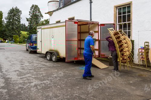 Preview: Pitlochry Scotland - September 12 2019: Man Teasing A Tourist How To Load Chairs Into A Truck From