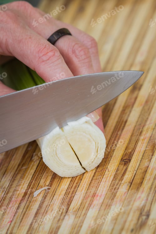 Preview: Action Close-Up Shot In A Home Kitchen With Slight Motion Of The Knife And Hand While Slicing A Leek
