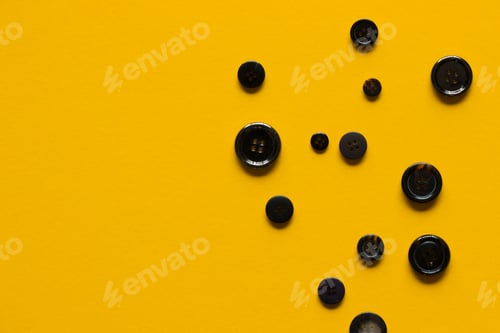 Preview: Black Clothes Sewing Buttons On Yellow Background