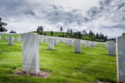Preview: Rows Of Tombstones In A Military Graveyard With Bright Green Spring Grass And Dramatic Storm Clouds