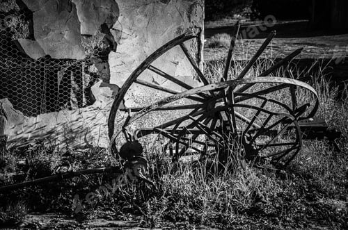 Preview: Old Wagon Wheel By An Old Building In Black And White