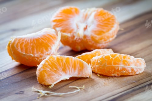 Preview: Close Up Of A Small Orange Or Tangerine On A Wooden Cutting Board