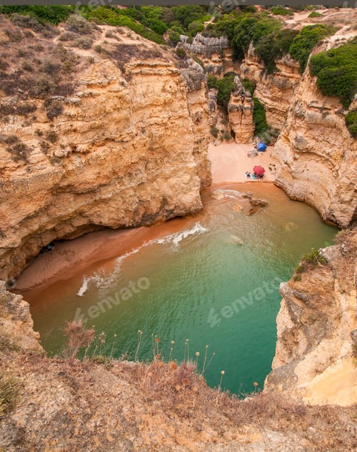 Preview: Portrait Photo Of A Hidden Cove With A Secret Beach With Tourists Laying On It With An Umbrella