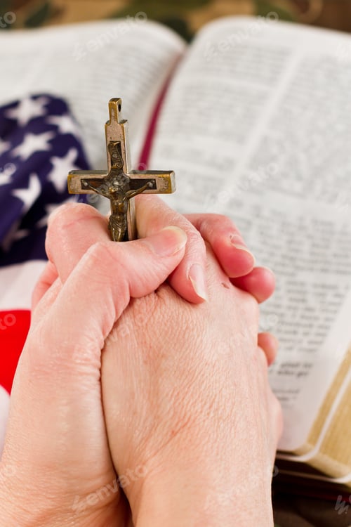 Preview: Adult Female Hands Holding A Crucifix With A Camouflage Background And An Open Bible With An