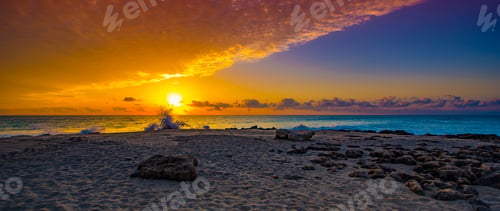 Preview: A Wide Angle View Of The Sunrise With A Foreground Of Limestone Rocks Scattered Over The Beach.
