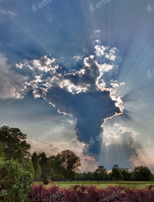 Visualização: Foto dela de uma nuvem alta em forma de bigorna sobre prados com raios solares