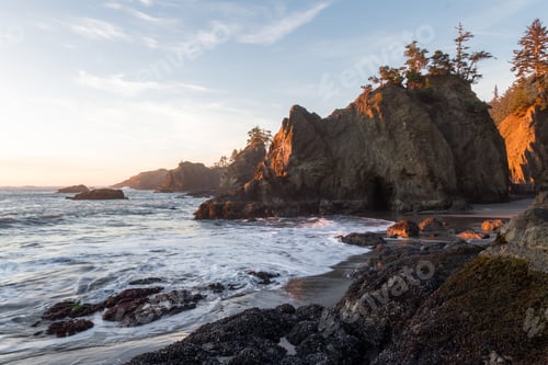 Preview: Beautiful Sunset In Secret Beach Oregon With A Soft Warm Glow On The Rocks And Evergreen Trees On
