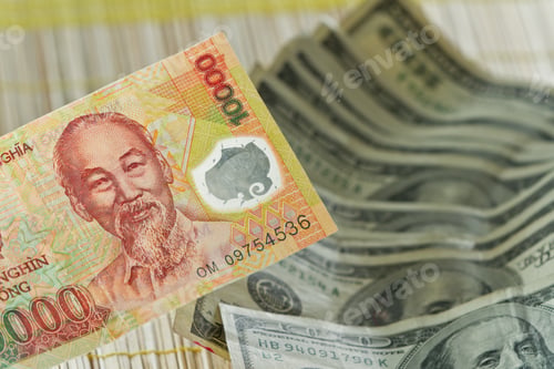 Preview: Vietnamese Dong In The Front With A Few Hundred Dollar Bills In The Background