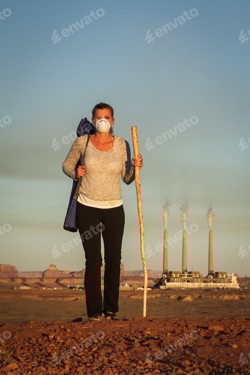 Preview: Concept Image Of A Woman Wearing A Mask And A Walking Stick Walking Away From A Coal Burning Power